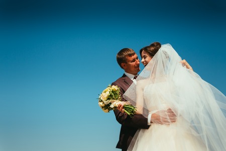 young bride and groom couple on the sky backgroundの写真素材