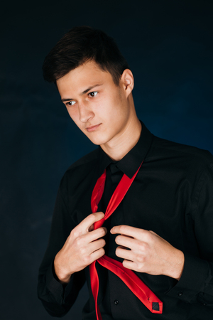 Portrait young guy on a dark studioの写真素材