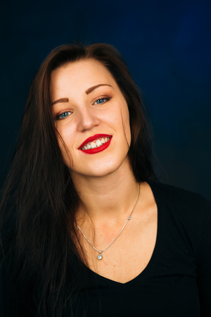 emotional girl smiling on a dark backgroundの写真素材