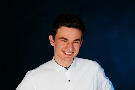 young brunette guy in a white shirtの写真素材