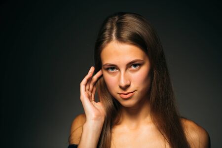 Portrait beautiful girl on a dark studio backgroundの写真素材