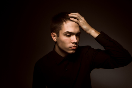 young guy on a dark studio backgroundの写真素材