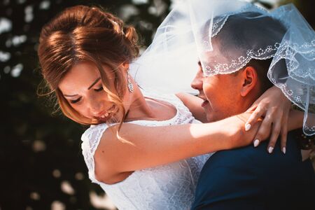 couple groom and bride hugging and kissing on nature park backgroundの写真素材