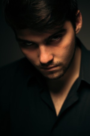 young brunette guy on a dark backgroundの写真素材