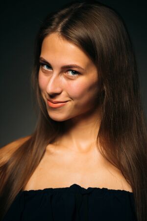 Portrait beautiful girl on a dark studio backgroundの写真素材