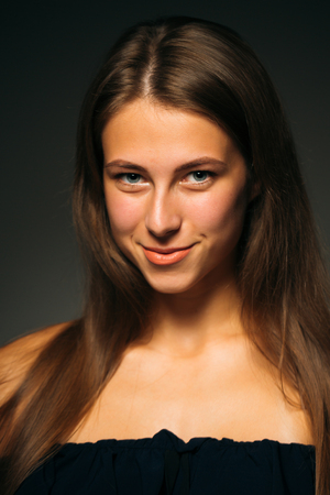 Portrait beautiful girl on a dark studio backgroundの写真素材