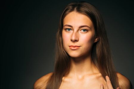 Portrait beautiful girl on a dark studio backgroundの写真素材