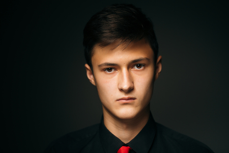 Portrait young guy on a dark studioの写真素材