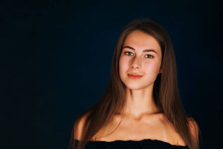 Portrait beautiful girl on a dark studio backgroundの写真素材