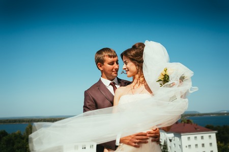 Young bride and groom couple on the sky backgroundの写真素材