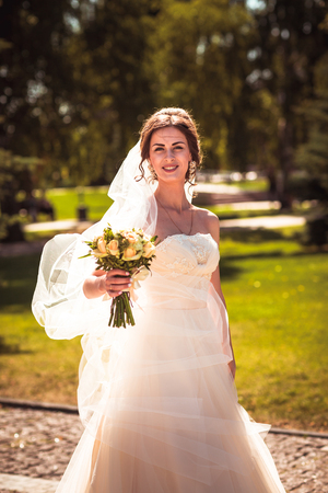 The beautiful brunette bride on a walk in parkの写真素材