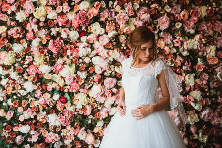 Beautiful bride on the background of a wall of flowersの写真素材