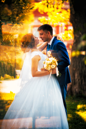 couple groom and bride against the background of orange leavesの写真素材
