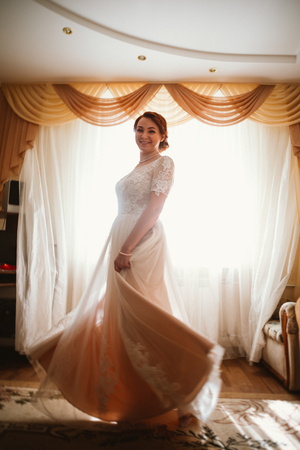 beautiful young bride near the window in full growthの写真素材