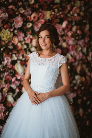 beautiful bride on the background of a wall of flowersの写真素材