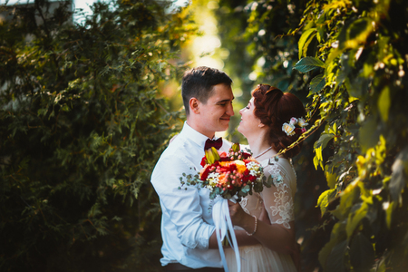 A bride and a groom in the foliage of treesの写真素材