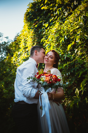 The bride and groom in the foliage of treesの写真素材