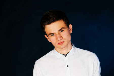 young brunette guy in a white shirtの写真素材