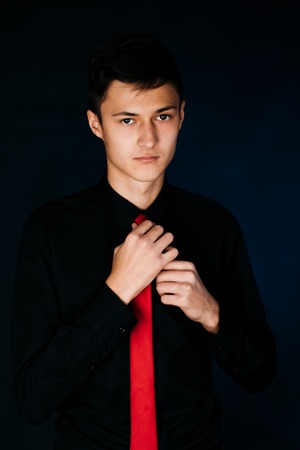 Portrait young guy on a dark studioの写真素材