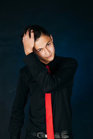 Portrait young guy on a dark studioの写真素材