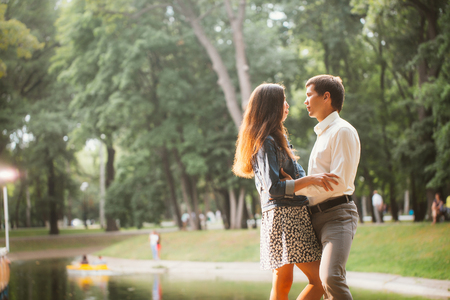 Beautiful young couple on the lake backgroundの写真素材