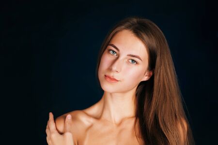 Portrait beautiful girl on a dark studio backgroundの写真素材