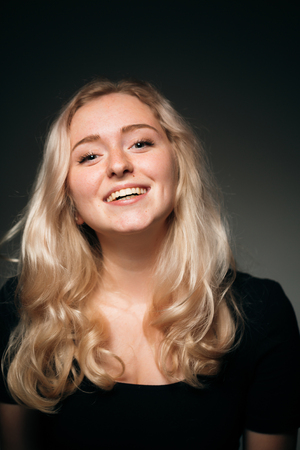 Young girl blonde on a dark backgroundの写真素材