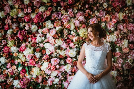 beautiful bride on the background of a wall of flowersの写真素材