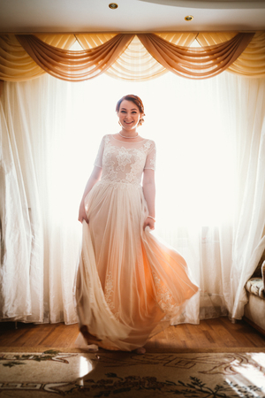 beautiful young bride near the window in full growthの写真素材