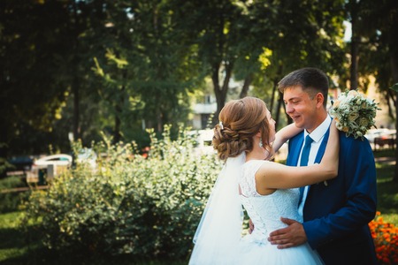 couple groom and bride hugging and kissing on nature park backgroundの写真素材