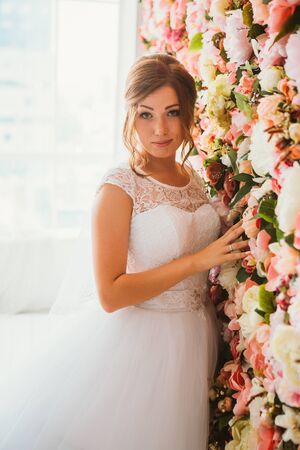 beautiful bride on the background of a wall of flowersの写真素材