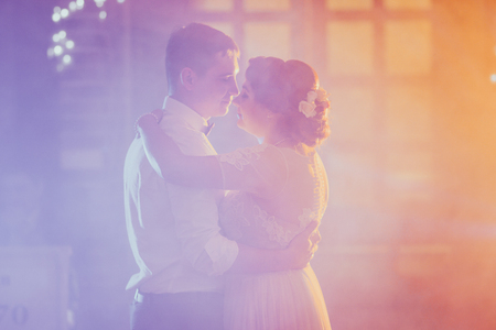 bride and groom dancing the first dance in the blurry backgroundの写真素材