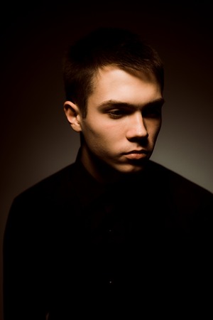 young guy on a dark studio backgroundの写真素材