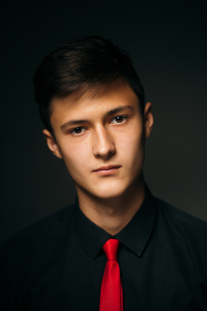 Portrait young guy on a dark studioの写真素材