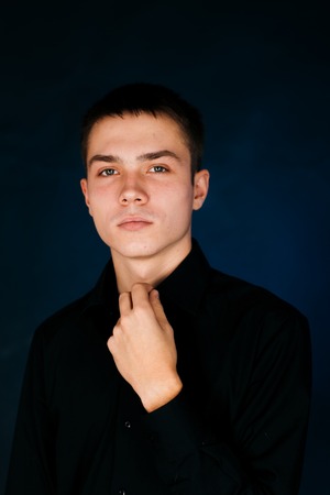 young guy on a dark studio backgroundの写真素材