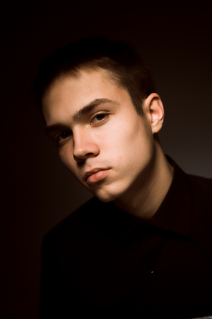 young guy on a dark studio backgroundの写真素材