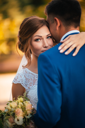 couple groom and bride hugging and kissing on nature park backgroundの写真素材