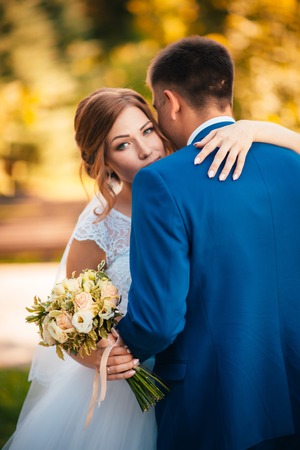 couple groom and bride hugging and kissing on nature park backgroundの写真素材