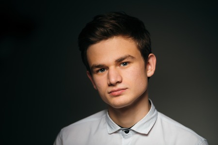 young brunette guy in a white shirtの写真素材