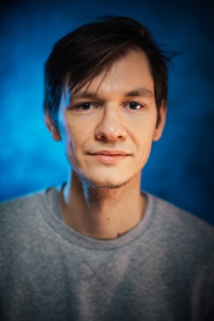portrait emotional young man on blue backgroundの写真素材