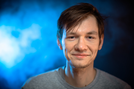 Portrait emotional young man on blue backgroundの写真素材