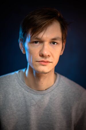portrait emotional young man on blue backgroundの写真素材