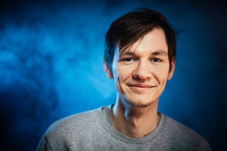 portrait emotional young man on blue backgroundの写真素材