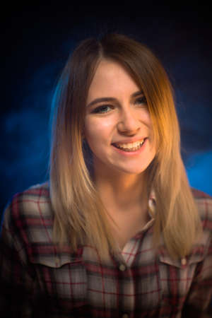 portrait smiling girl on blue background in studio