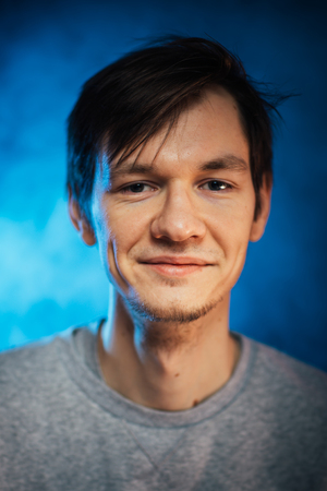 portrait emotional young man on blue background.の写真素材