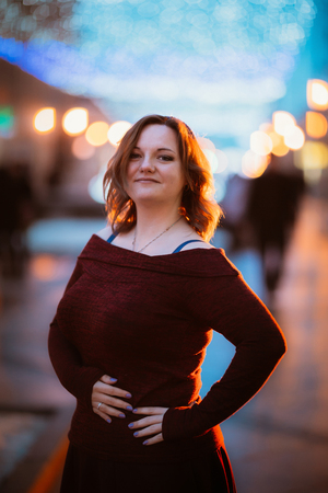 young woman posing on winter street background.の写真素材