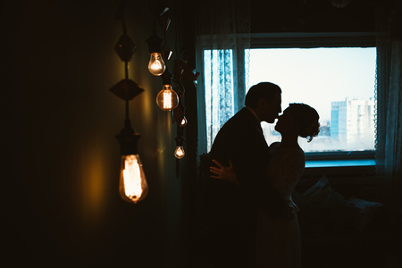 Silhouette of a bride and a groom in light studio.の写真素材