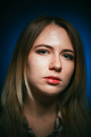 portrait smiling girl on blue background in studio.の写真素材