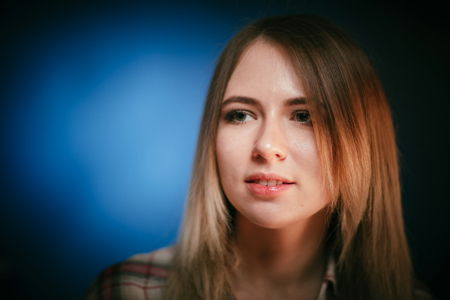 portrait smiling girl on blue background in studio.の写真素材