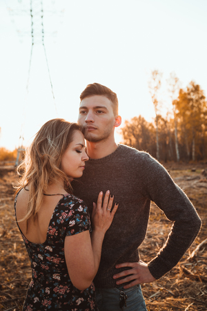 guy and girl in the field on the sunset background.の写真素材